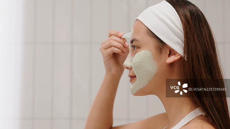 亚洲女性在护肤过程中使用泥状面膜图片素材