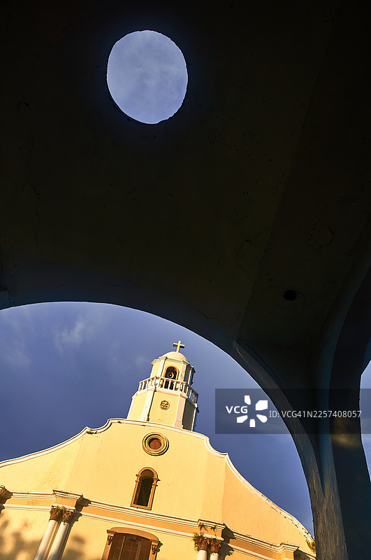 照片透过一个漂亮的拱门展现了马兰奈圣彼得宗徒教区教堂的历史外观，该教堂位于奎松省。图片素材