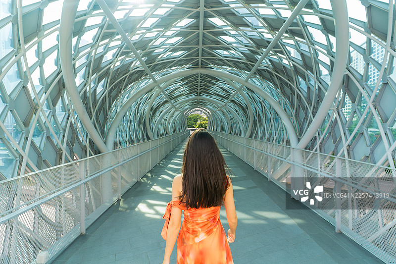 阳光穿过萨洛马大桥隧道，一名女子正在其中行走图片素材