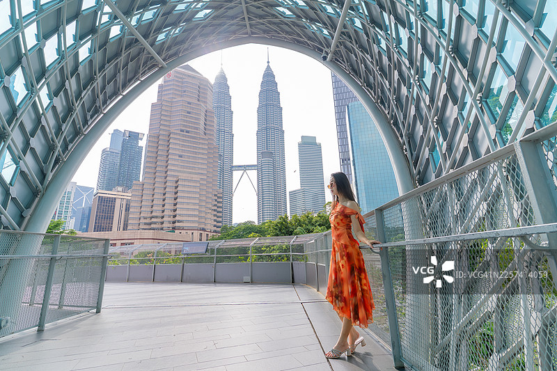 女子走在萨洛马大桥上，远眺双子塔图片素材