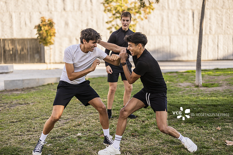 年轻男子在公园里享受友好切磋图片素材
