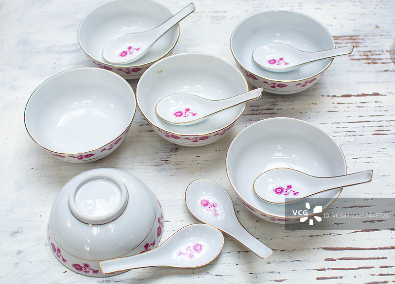 白色碗碟和勺子，带有粉色花卉图案图片素材