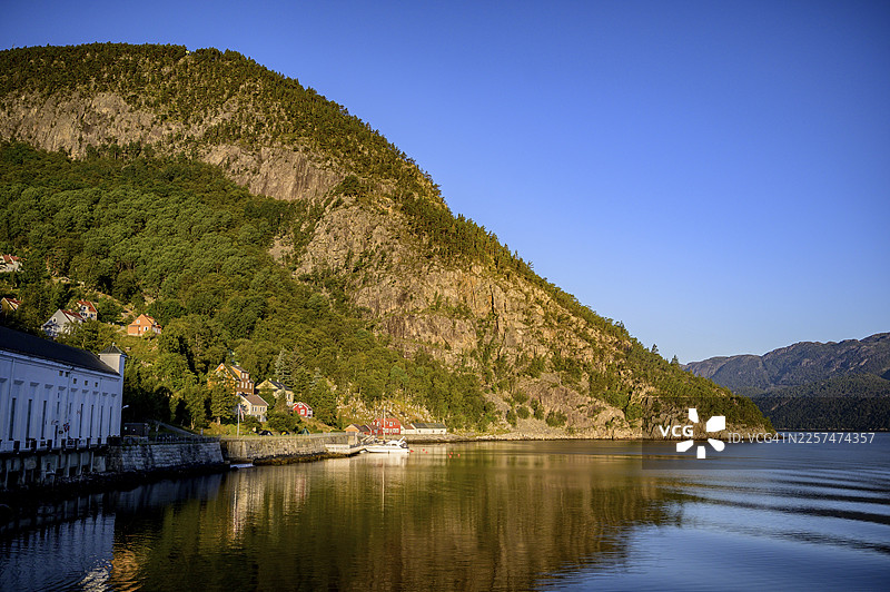 挪威罗加兰郡吕瑟峡湾，哥伦布渡轮视角下的吕瑟峡湾，峡湾平静，岸边有山峦和风景如画的村庄图片素材