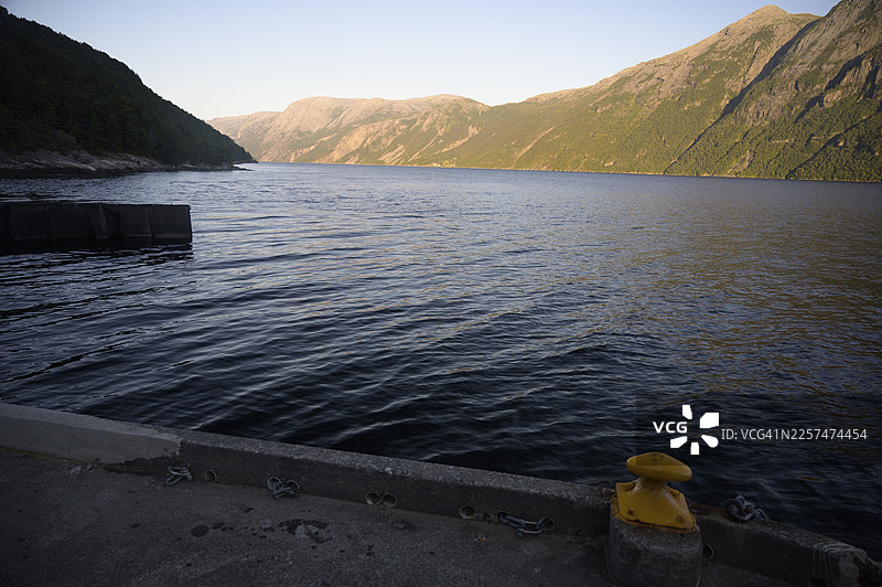 挪威罗加兰松德，黄昏时分海岸线，平静的海水和山间的阴影图片素材