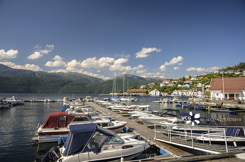 挪威罗加兰桑德，晴天时港口停泊的船只，背景是群山图片素材