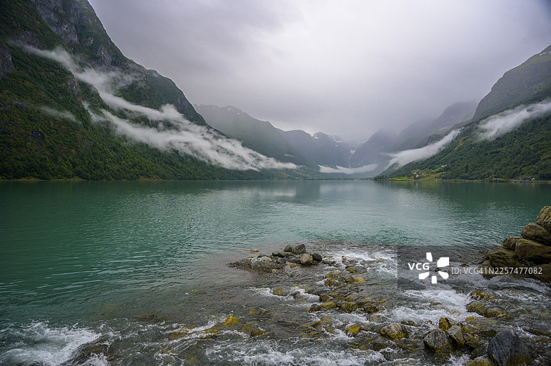挪威韦斯特兰郡奥尔登，宁静的峡湾风光，远山云天，近有布里克斯达尔冰川环绕的青翠山丘图片素材