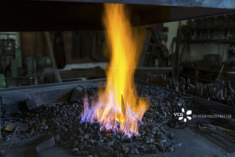 一位铁匠在德国萨克森州德累斯顿-比劳的Ehnert铁匠铺锻造图片素材