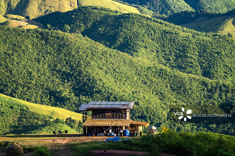 绿色山丘上的太阳能住宅，代表可持续生活图片素材
