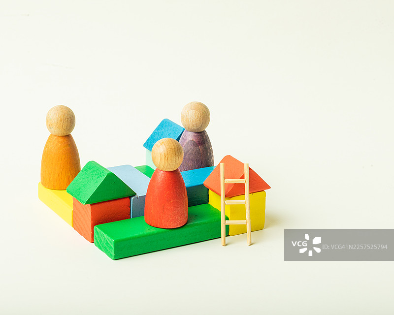 色彩鲜艳的木质积木和玩偶，置于充满趣味的房屋和梯子场景中图片素材