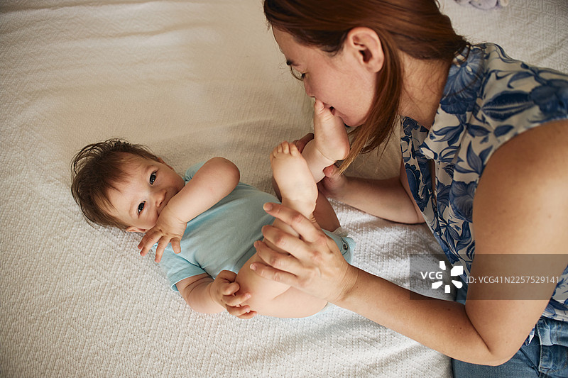 快乐的婴儿男孩和他的母亲一起玩耍图片素材