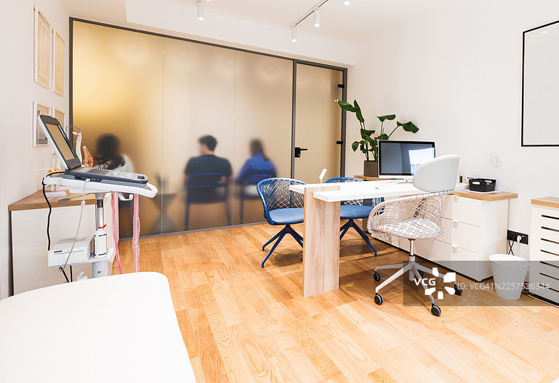 现代骨科诊所办公室，配有办公桌、玻璃门、植物和舒适的康复等候区图片素材