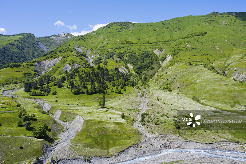 格鲁吉亚军事公路科维舍蒂和古道里之间，姆茨赫塔-姆蒂亚涅蒂地区，白阿拉瓜维河，高加索山脉，格鲁吉亚的绿色山丘、山谷和河流，周围环绕着群山和茂密的植被的风景图片素材