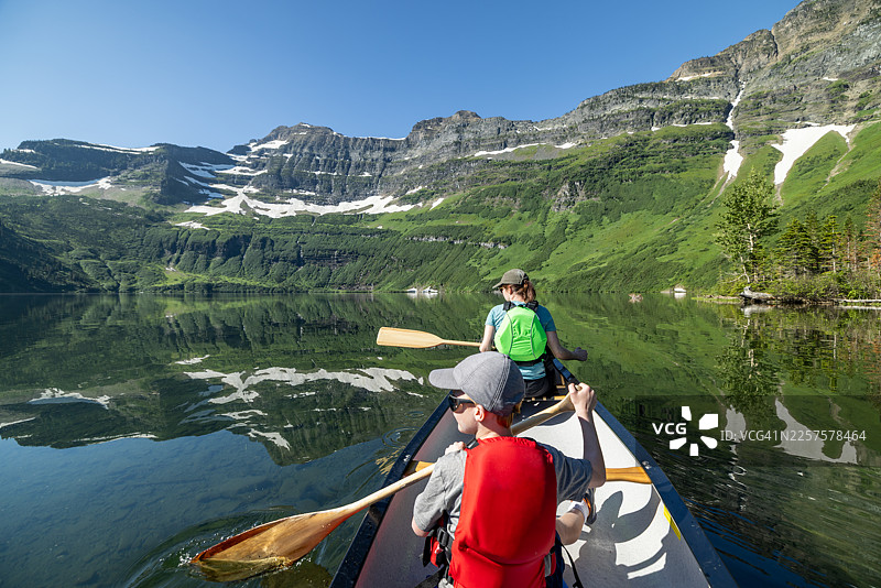 母子二人正在加拿大落基山脉沃特顿湖国家公园的卡梅伦湖上划独木舟图片素材