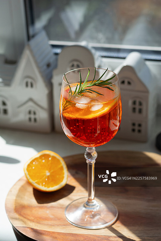 浅色背景下的葡萄酒杯装阿佩罗开胃酒。夏日酒精饮品，清爽的意大利开胃酒。图片素材