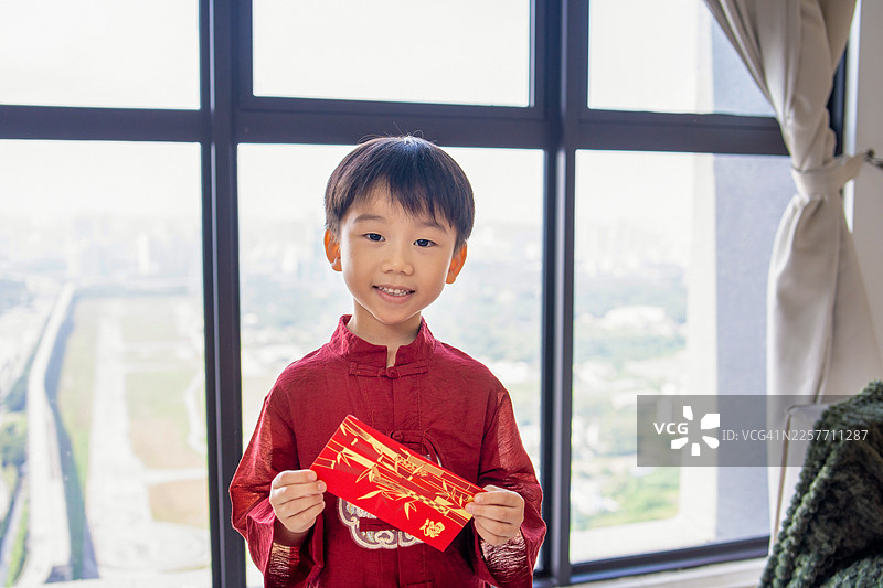 男孩在中国新年拿着红包图片素材