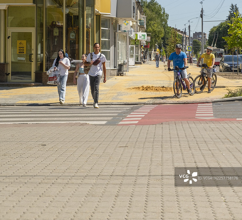 夏日里，人们和骑行者正在穿越卢茨克市的街道图片素材