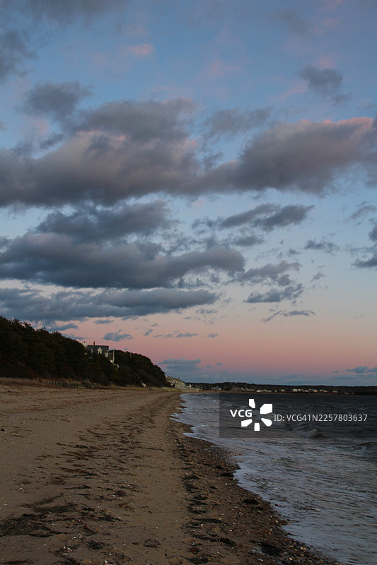 日落时分，科德角粉红色的天空中飘浮着魔法般的云彩。马萨诸塞州惠灵顿的梅奥海滩。图片素材