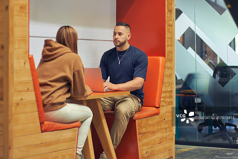 两位同事在一个小型工作站讨论想法图片素材