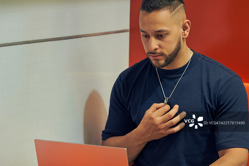 一名男子用手指激活他的智能项链，并为其下达指令图片素材