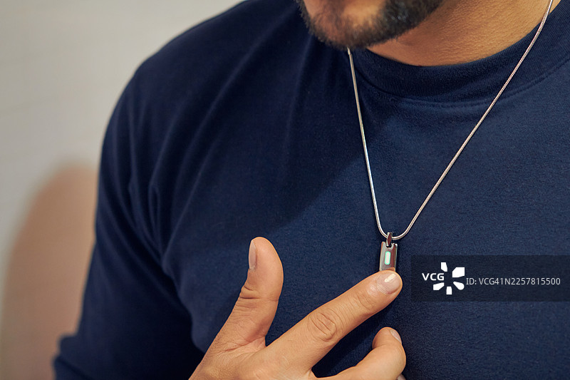 男子用手指激活智能项链并发出指令图片素材