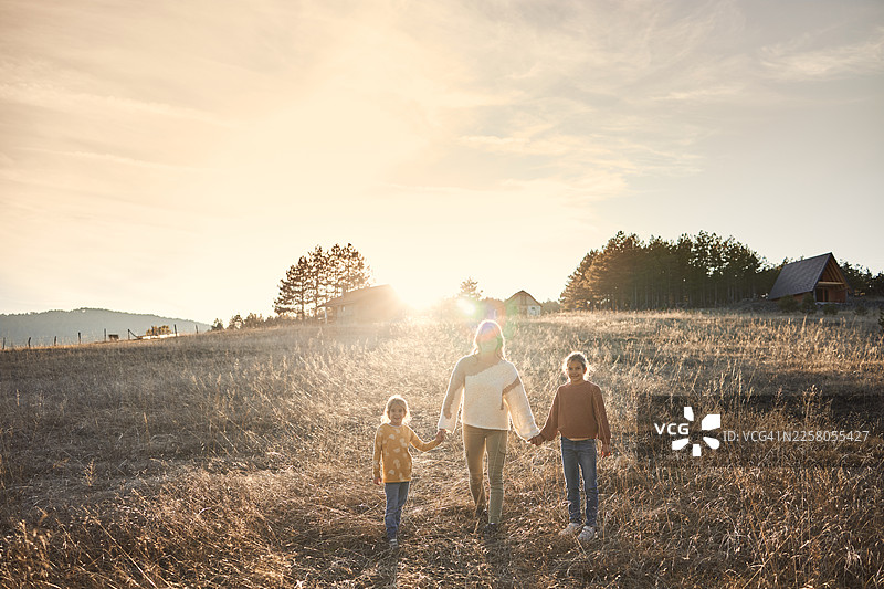 快乐的女孩们与她们的母亲在自然中奔跑图片素材