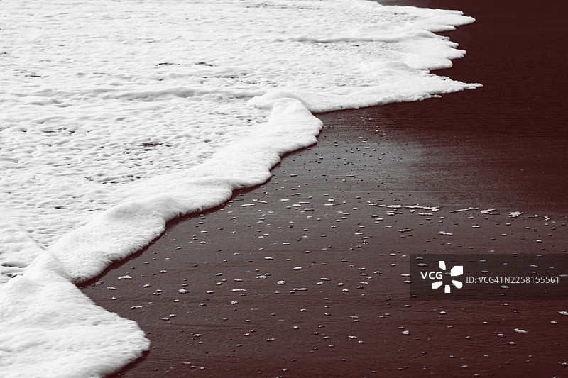 尼加拉瓜莱昂的黑沙滩上，海浪拍打激起的浪花图片素材