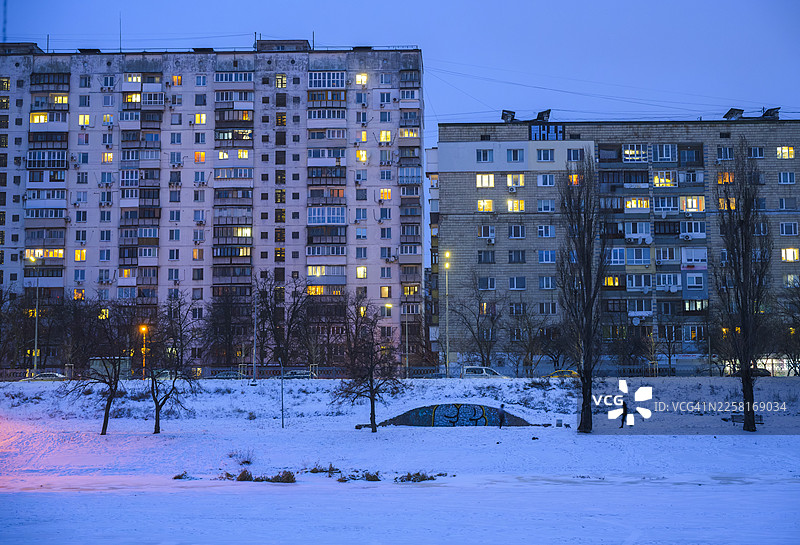 寒冷冬日傍晚，城市公寓楼灯火辉煌图片素材