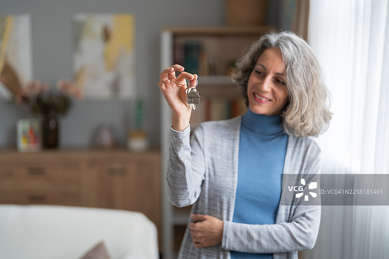 快乐的年长女性，手中拿着新家的钥匙图片素材
