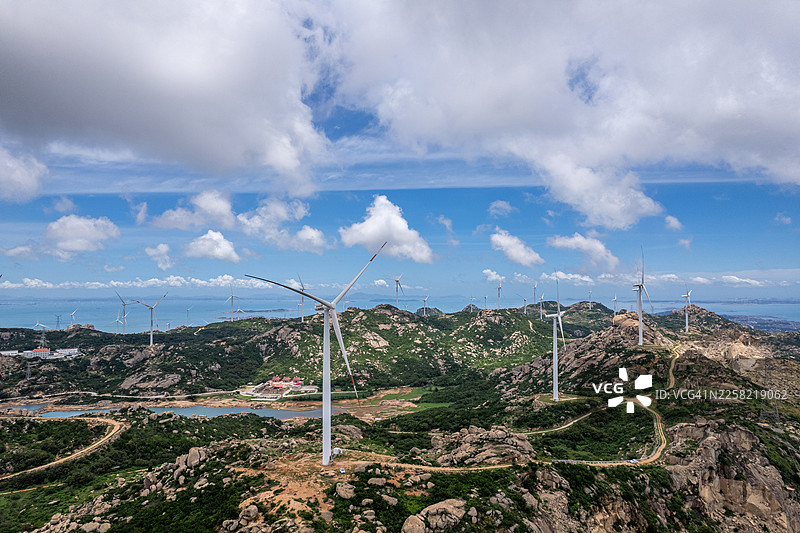 云层下的山峦上风力涡轮机的空中视角图片素材