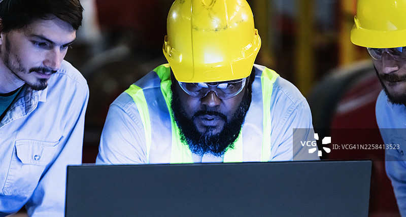 工厂里的工人在看电脑显示器图片素材