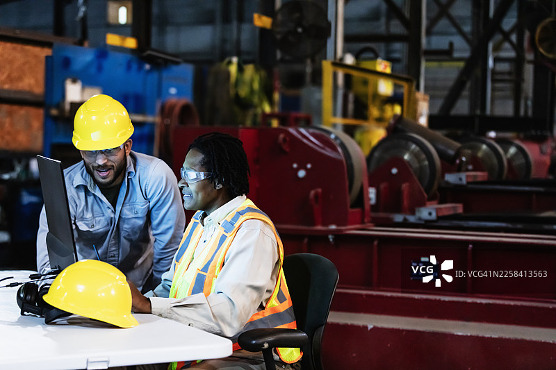 两位工厂工人在看电脑显示器图片素材