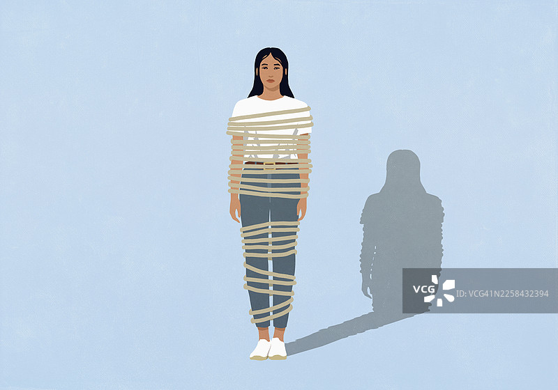 严肃的年轻女子被绳子缠绕，背景为蓝色图片素材