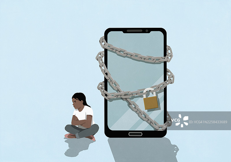 愤怒的女孩双臂交叉坐着，旁边是一个上了锁的大屏智能手机图片素材