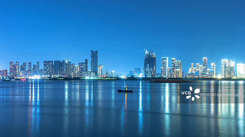 夜晚，水边的城市滨水天际线与现代摩天大楼图片素材