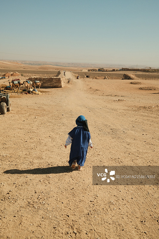 摩洛哥撒哈拉儿童行走在沙漠公路上图片素材