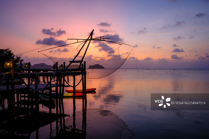 日落时分泰国宋卡湖畔芭提雅阁岛传统渔网的剪影图片素材