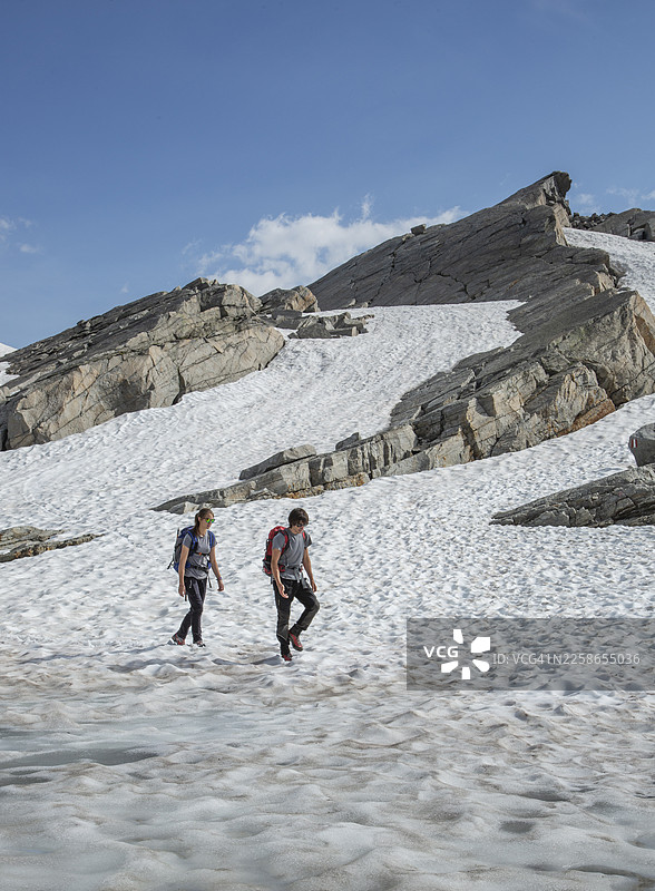两位登山者在阿尔卑斯山雪原上行进图片素材
