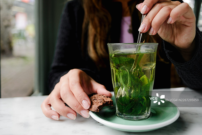 阿克马咖啡馆里，薄荷茶和饼干的特写，旁边有双手图片素材