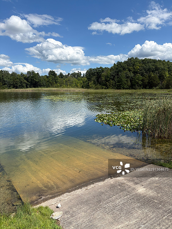 美国豪伊，蓝天白云下宁静湖泊的风景，带有船坡道，地点：Cedar Lake Public Access Site图片素材