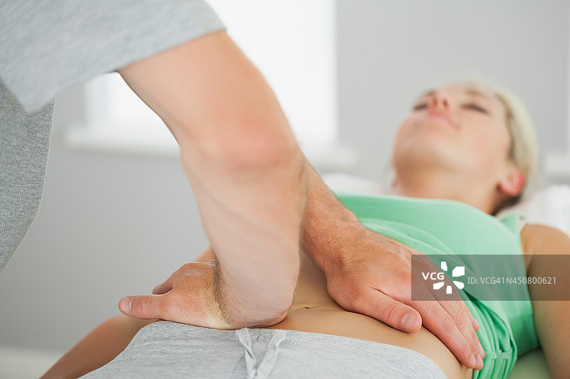 理疗师检查患者骨盆对齐情况图片素材