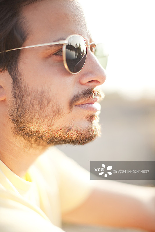 戴着太阳镜，看向远方的年轻男人图片素材