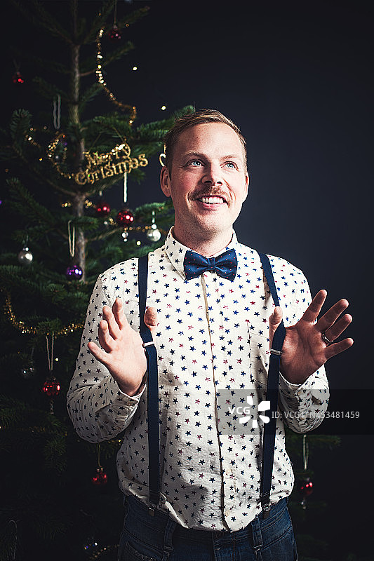 圣诞树前的英俊男人图片素材