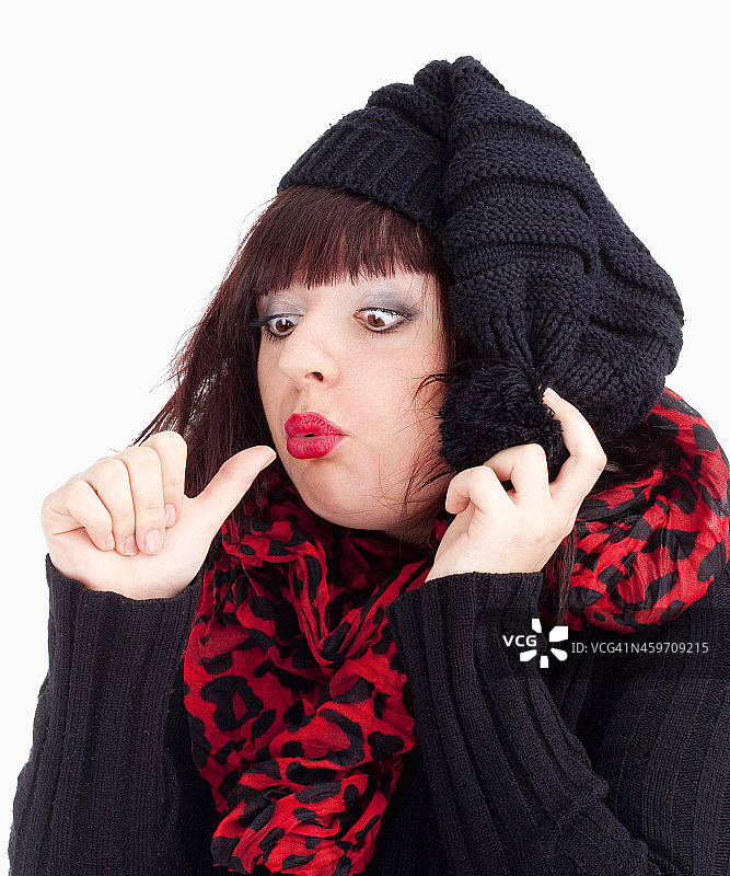 戴黑色帽子的年轻女人看着她的拇指图片素材