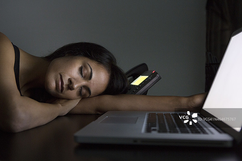 女商人晚上在办公桌前睡觉图片素材
