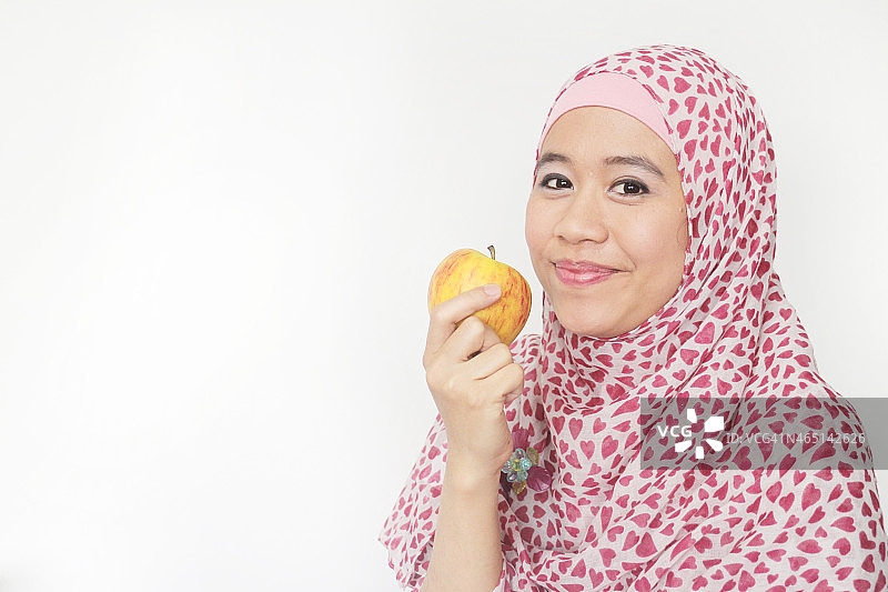穆斯林女孩吃新鲜苹果图片素材