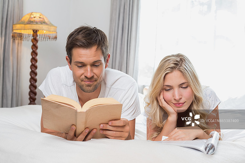 在床上看书的悠闲情侣图片素材
