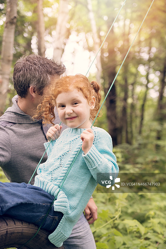 父女在户外玩轮胎秋千图片素材