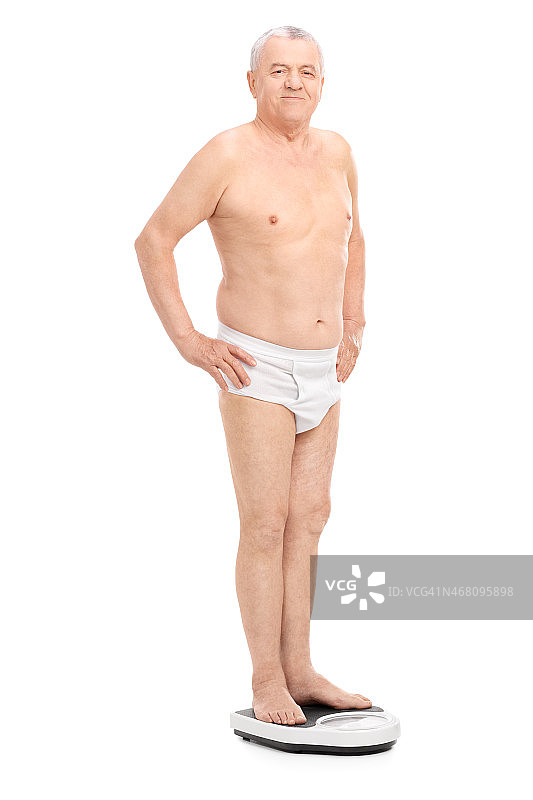 穿着内衣站在体重秤上的老年男人图片素材
