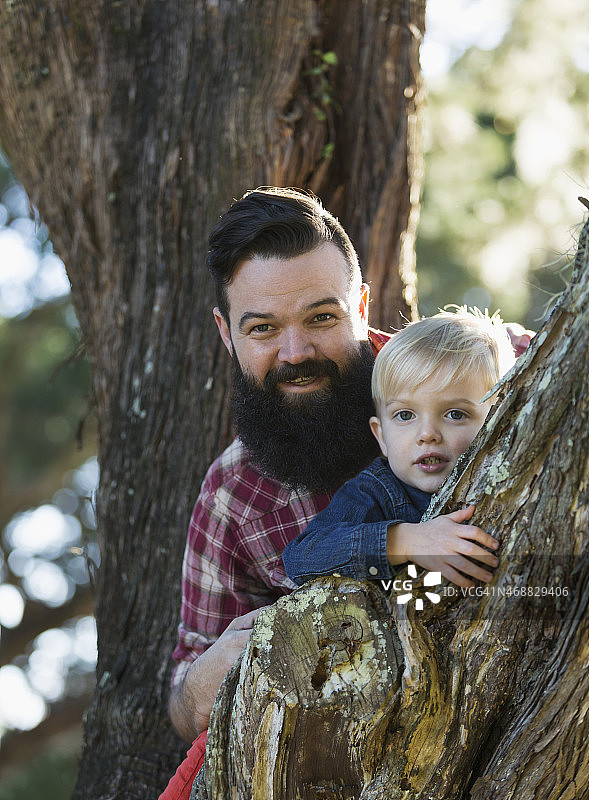 深发父亲和金发男孩一起爬树图片素材