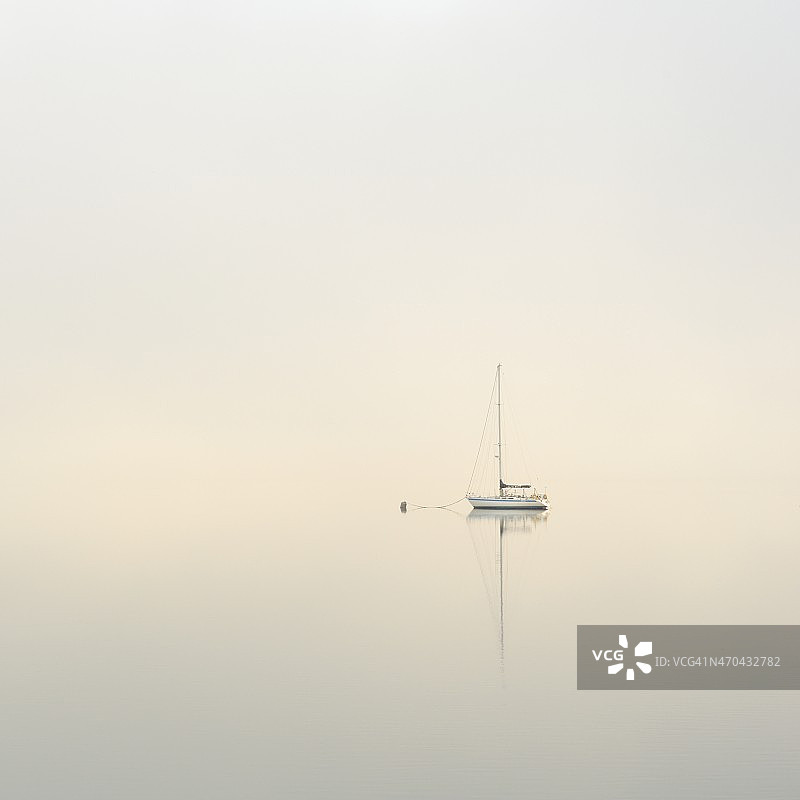 黎明时分停泊在平静雾湖上的游艇图片素材